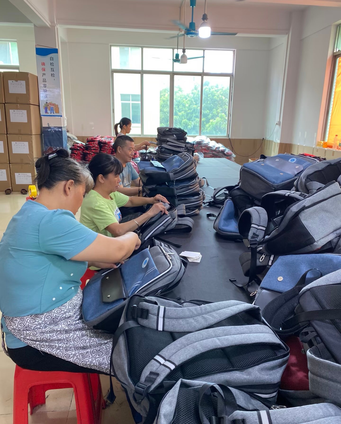 Factory team inspecting finished backpacks before packing
