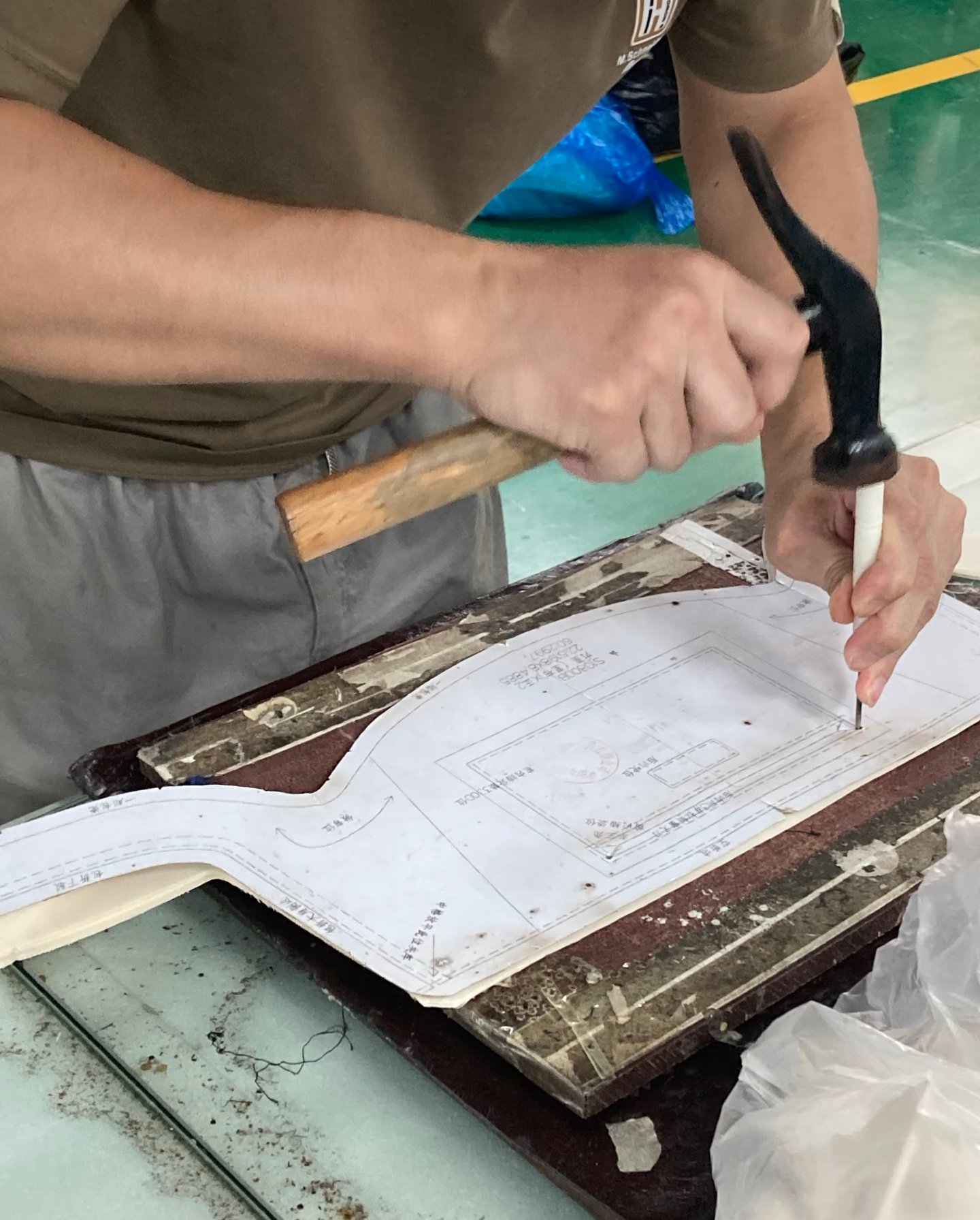 Worker preparing a paper pattern for custom bag production