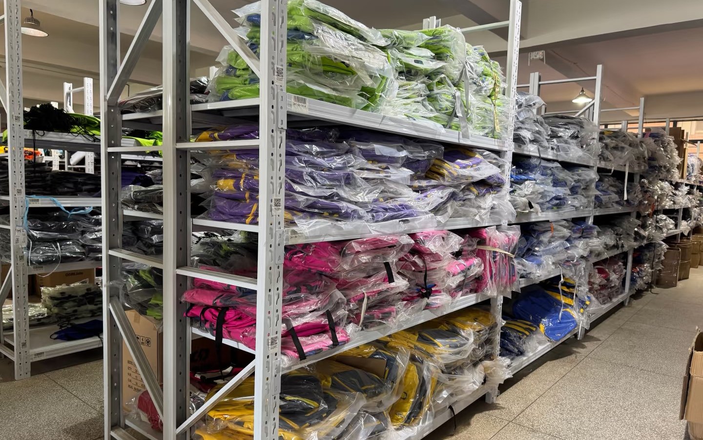 Packaged finished backpacks organized by color in factory storage